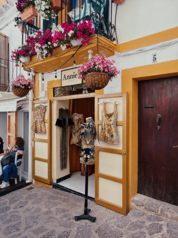 Ochre shopfront framed by flowers and open doors